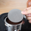 Puck screen placed on a tamped espresso puck